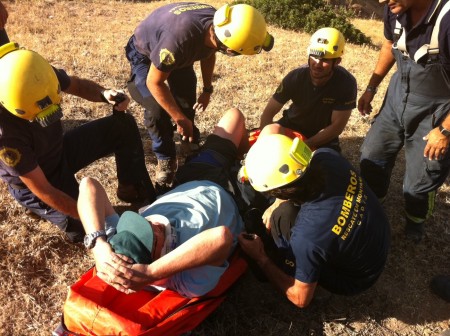 Los bomberos del grupo de rescate en montaña atienden al parapentista herido.