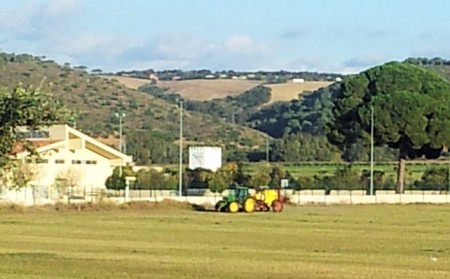 Tractor fumigando junto al colegio.