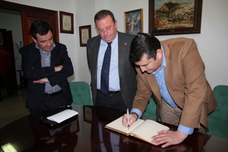 Antonio Sanz firma en el libro de honor del Ayuntamiento de Arcos, ante Núñez y Loaiza.