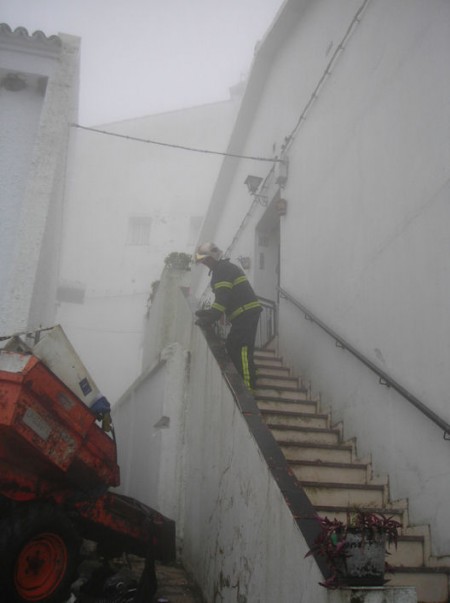 Un bombero ante la entrada de la vivienda siniestrada.