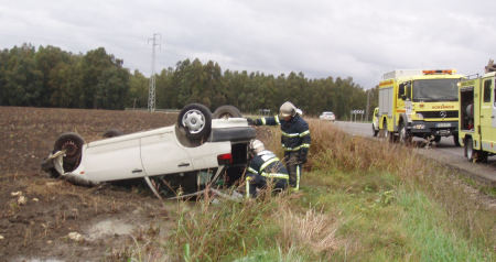 Los bomberos, durante su intervención ante el coche accidentado.