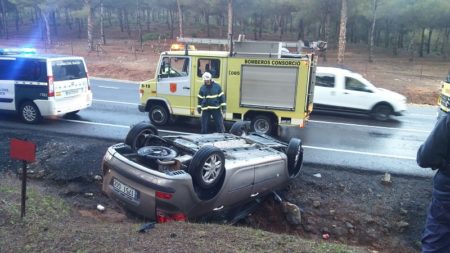 El coche accidentado y los bomberos.