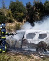 Un bombero sofoca el incendio del vehículo.