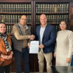El delegado territorial y el alcalde de Villamartín muestran el documento suscrito.